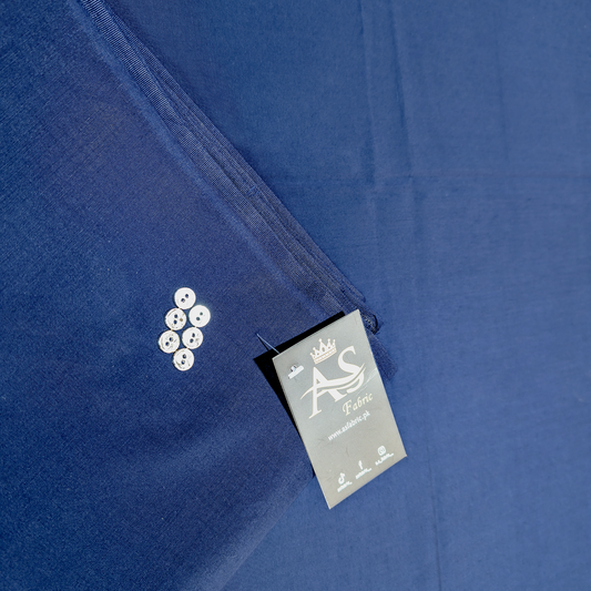 Close-up of a blue shirt with a label and buttons on a matching fabric background